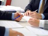 people-in-suits-looking-over-papers-on-desk